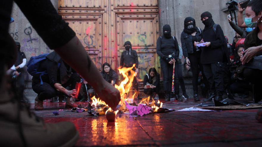 Un grupo de mujeres se manifiesta contra los feminicidios a las puertas del Palacio Nacional de México