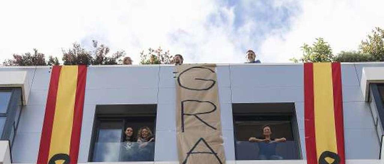 Paula Rojo y Patricia Ibarrondo colocan la decoración; arriba, las banderas y el cartel con la leyenda &quot;Gracias&quot;.