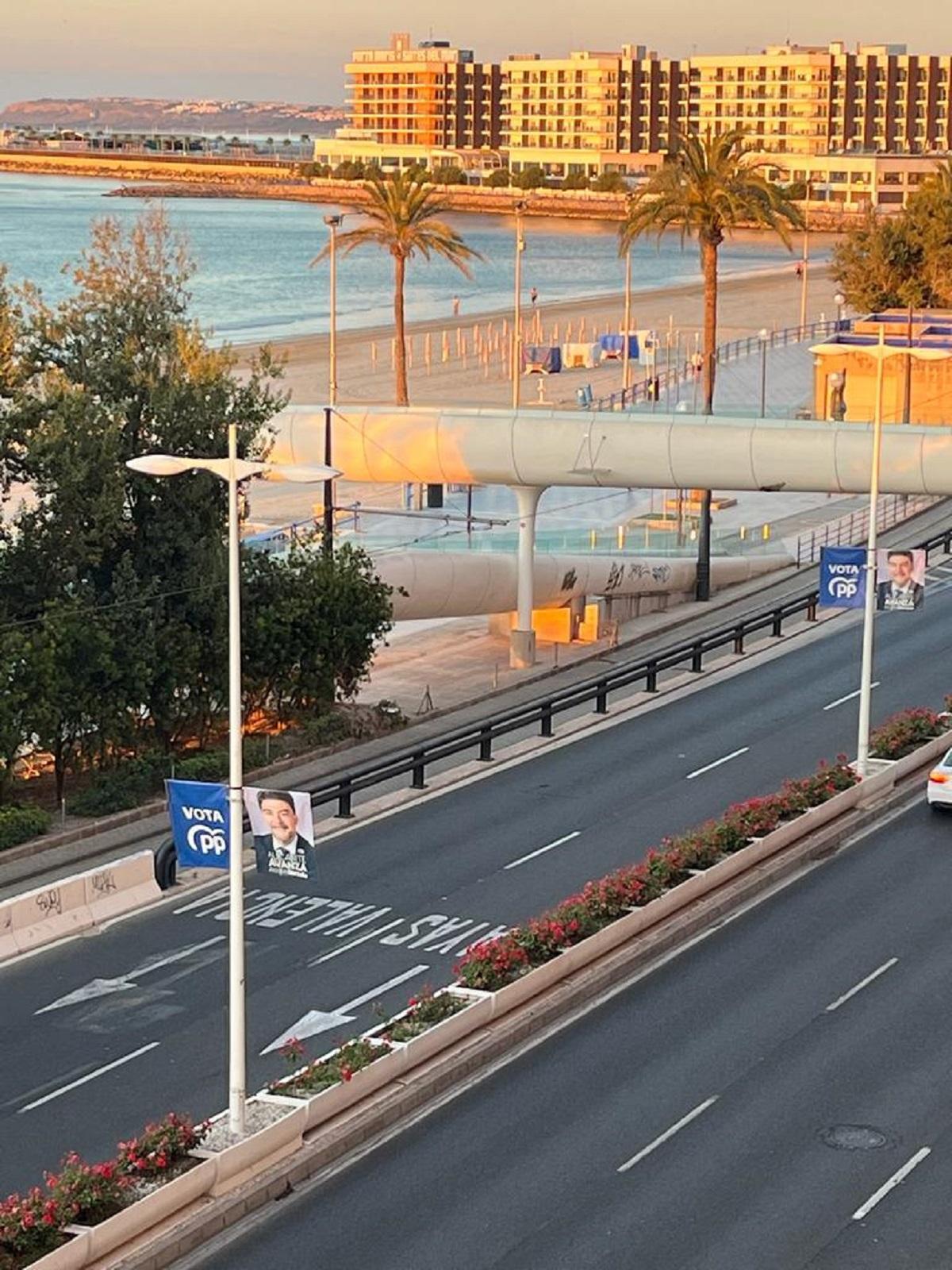 Banderolas con la imagen de Barcala junto a la playa del Postiguet.