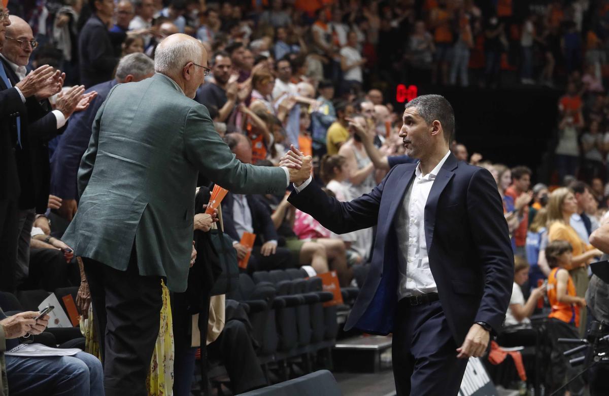 Rubén Burgos, que choca la mano de Juan Roig, el propietario del club, seguirá al frente del banquillo