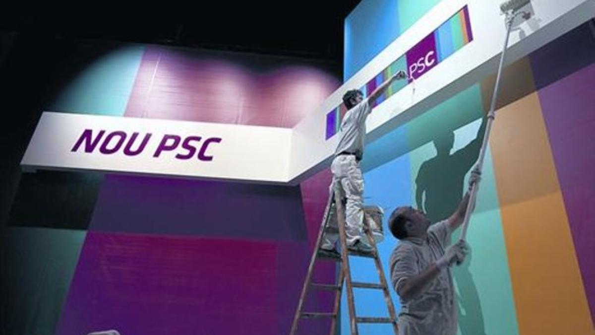 Dos operarios pintan las paredes del escenario del Palau de Congressos de Barcelona donde se celebrará el cónclave del PSC, ayer.