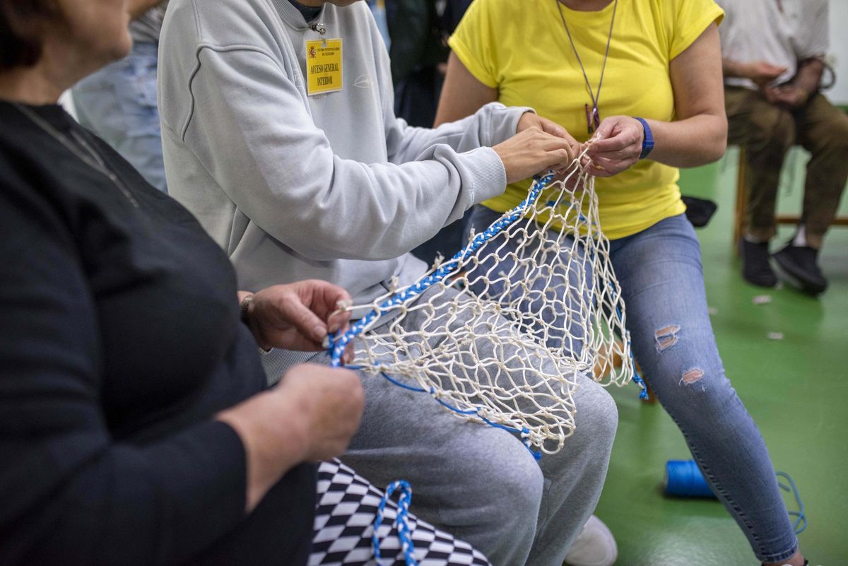 Jesús trabaja con dos internas en un bolso.