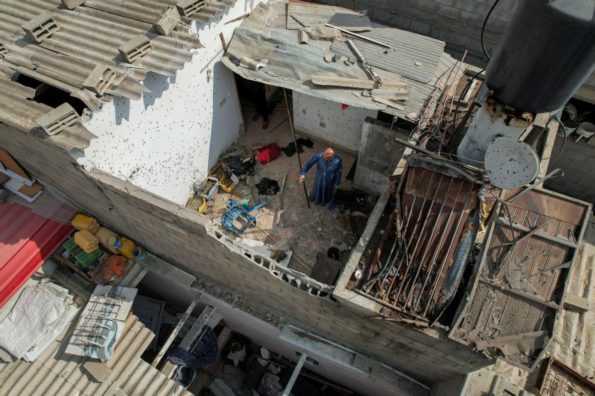 Los palestinos inspeccionan una casa dañada en medio de los combates entre Israel y Gaza, en el norte de la Franja de Gaza