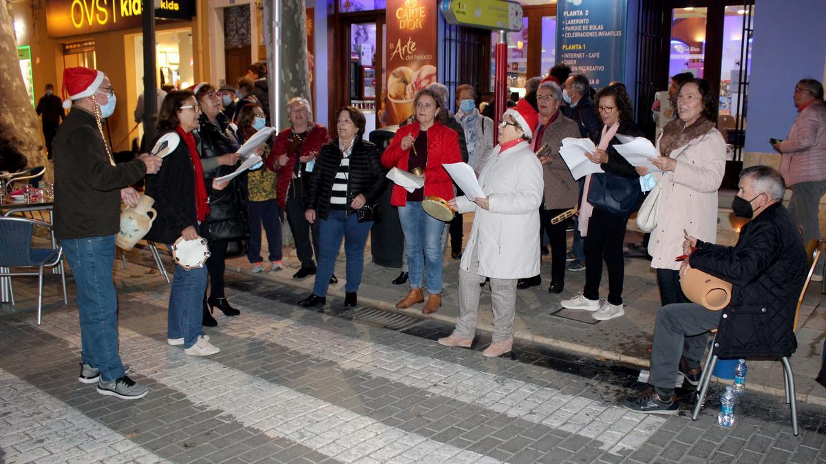 Un grupo de personas cantan villancicos en la calle en una actividad más de las fiestas en Dènia.