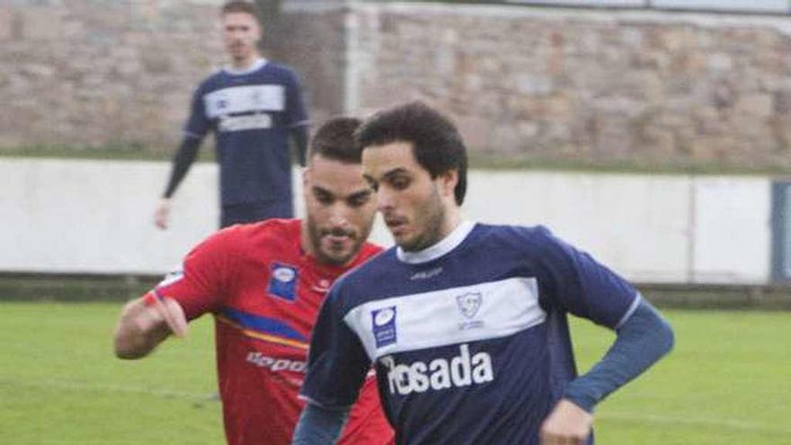 El jugador del Marino David González, con el balón, perseguido por Rueda, capitán del Condal.