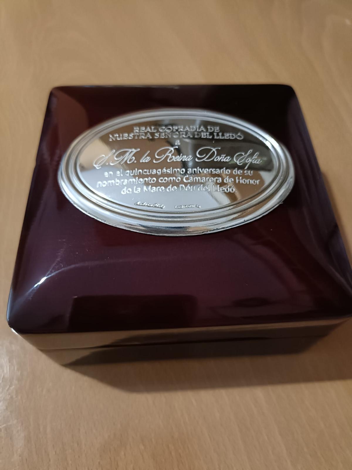 Placa en la caja entregada a la reina Sofía y en cuyo interior estaba la medalla de la Real Cofradía de la Virgen del Lledó.