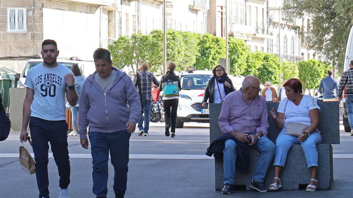 Un hombre y una mujer, sentado en uno de los bancos de la rúa Elduayen.