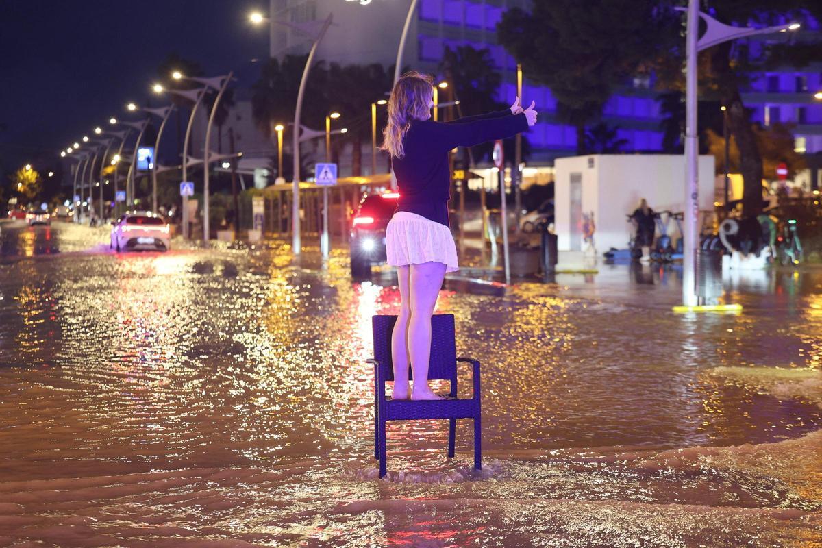 Una turista en Platja d'en Bossa durante las inundaciones de este año.