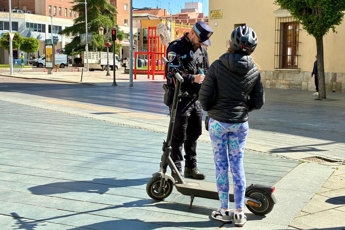 Agente de la Policía Local en el centro de Badajoz durante una labor informativa con una conductora de VMP.