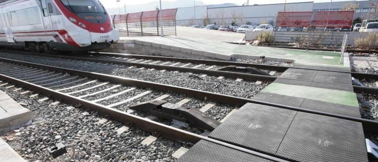 Un tren espera en el andén de la estación de Tavernes junto al paso habilitado para los peatones sobre las vías.