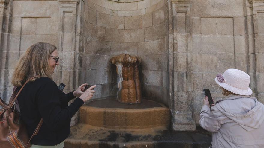 Dos turistas fotografían la fuente de As Burgas en una visita reciente a la ciudad. |  // ALÁN PÉREZ