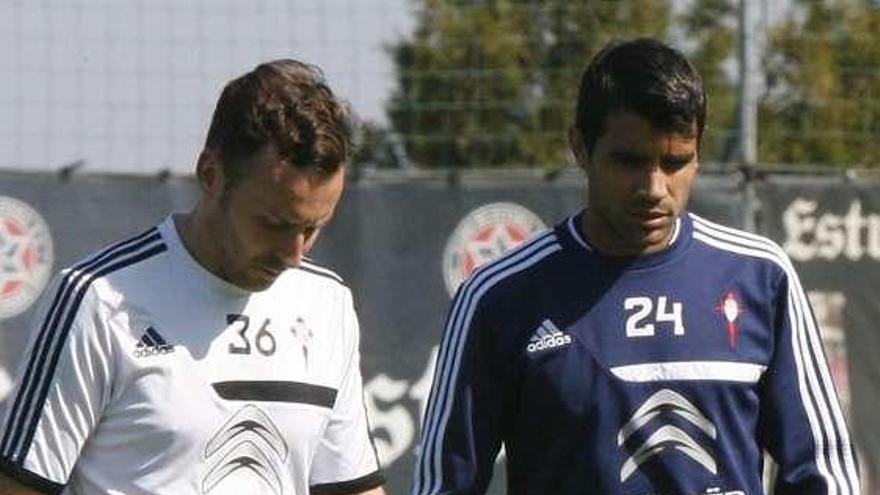 Augusto camina pensativo con uno de los recuperadores del Celta, ayer en A Madroa.  // De Arcos