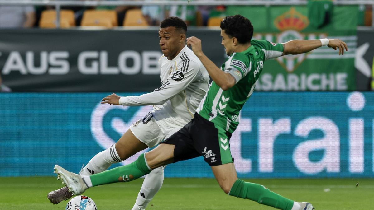 SEVILLA, 24/04/2026.- El delantero del Real Madrid Kylian Mbappé (izda) controla el balón ante el defensa del Real Betis Marc Bartra, durante el partido de la jornada 34 de LaLiga de fútbol que Real Betis y Real Madrid disputan este jueves en el estadio de La Cartuja, en Sevilla. EFE/Julio Muñoz