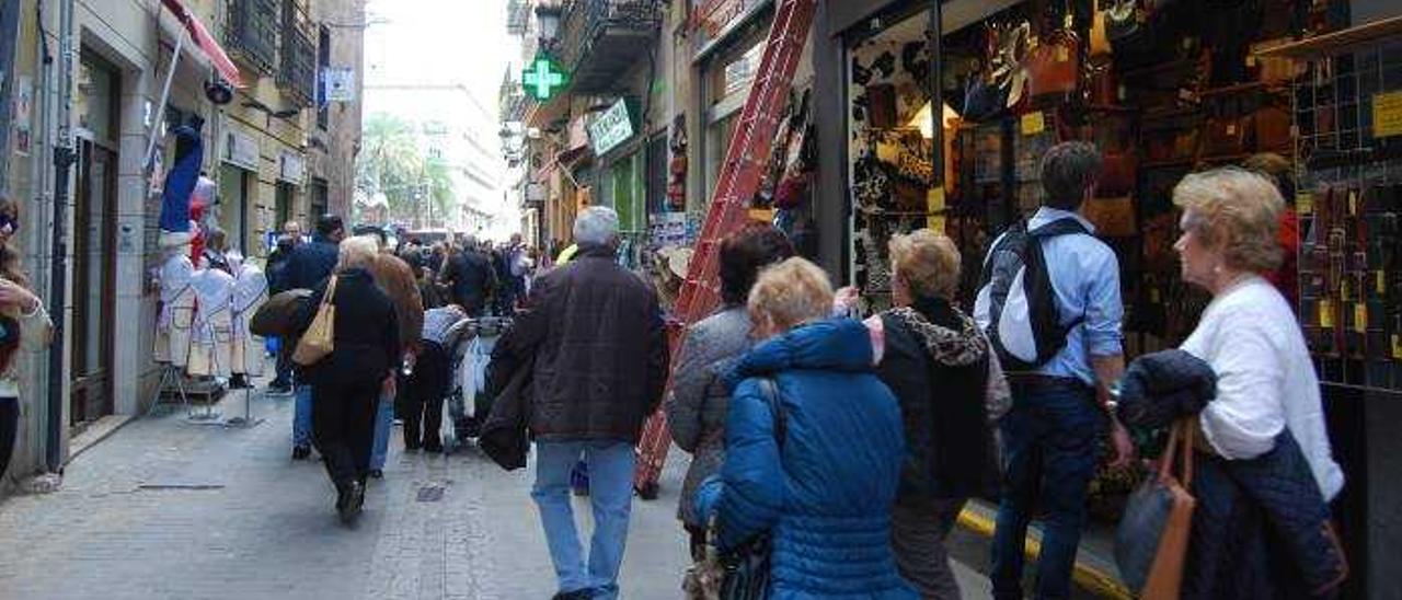 Un grupo de turistas pasa por delante de las tiendas de souvenirs de la calle Sombrería.