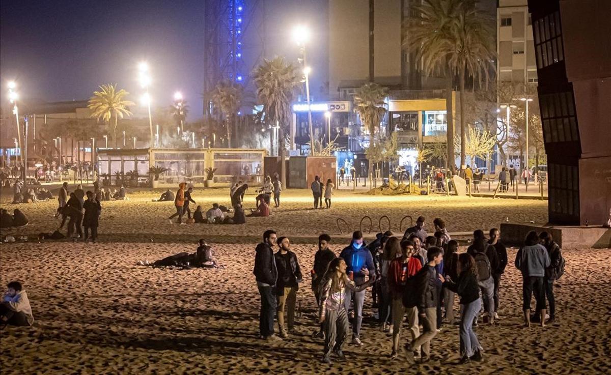 Un grupo de jóvenes bebe en la playa de la Barceloneta, a las nueve de la noche.