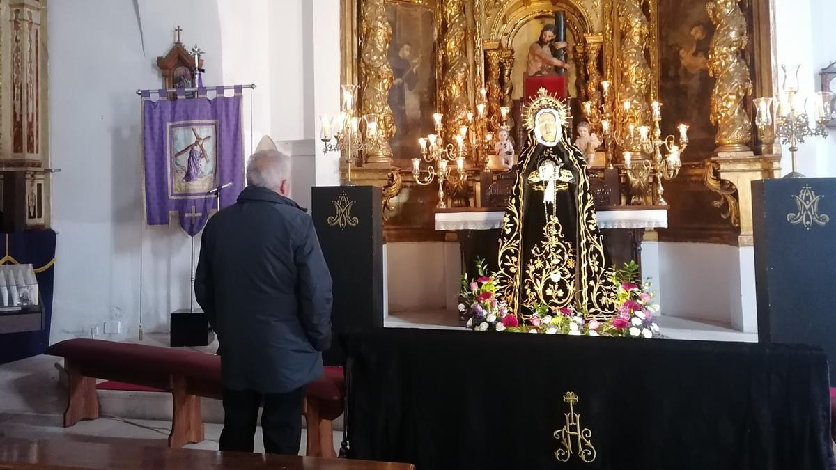 Un devoto observa la imagen de la Virgen de la Soledad en la iglesia de Santa Catalina