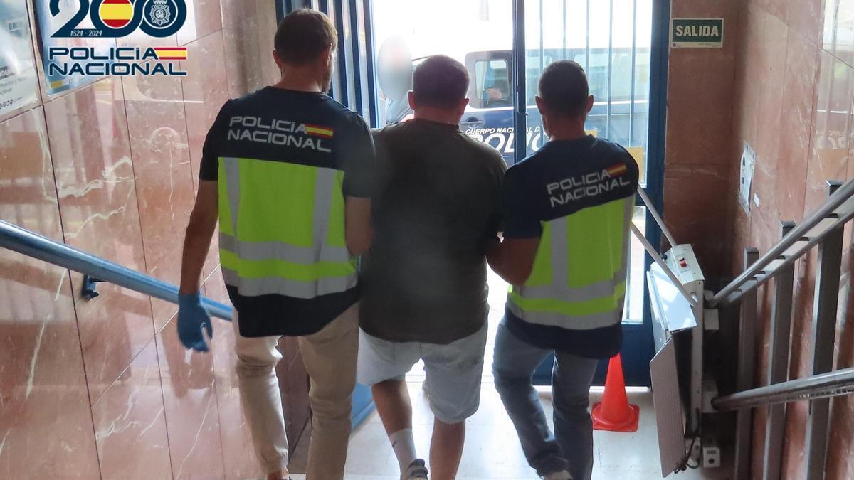 Agentes de la Policía Nacional con el detenido en la comisaría de Sagunt.