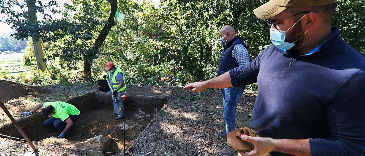 Mario Fernández, director de la excavación, ayer, muestra dónde hay un muro de cabaña.   | // ANXO GUTIÉRREZ