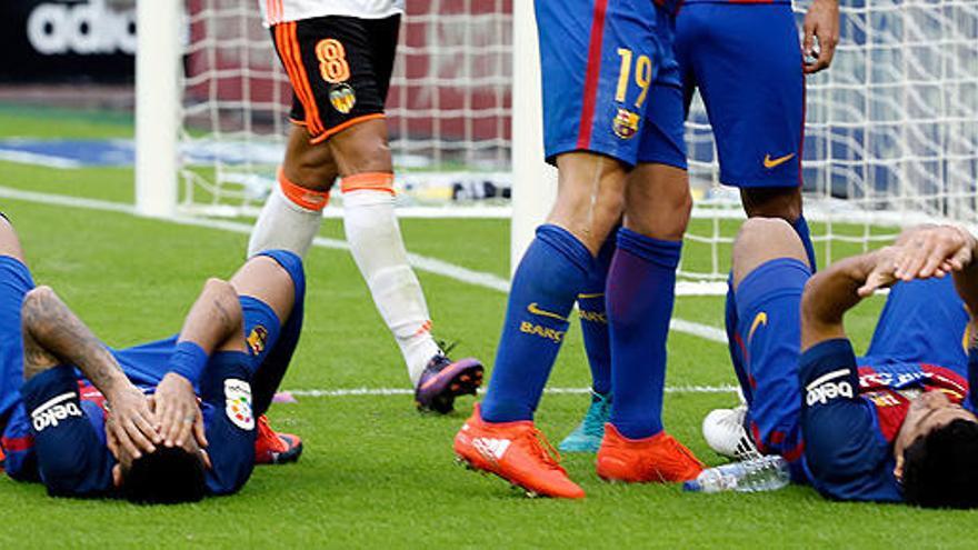 Neymar y Suárez, en el suelo tras el impacto de la botella.