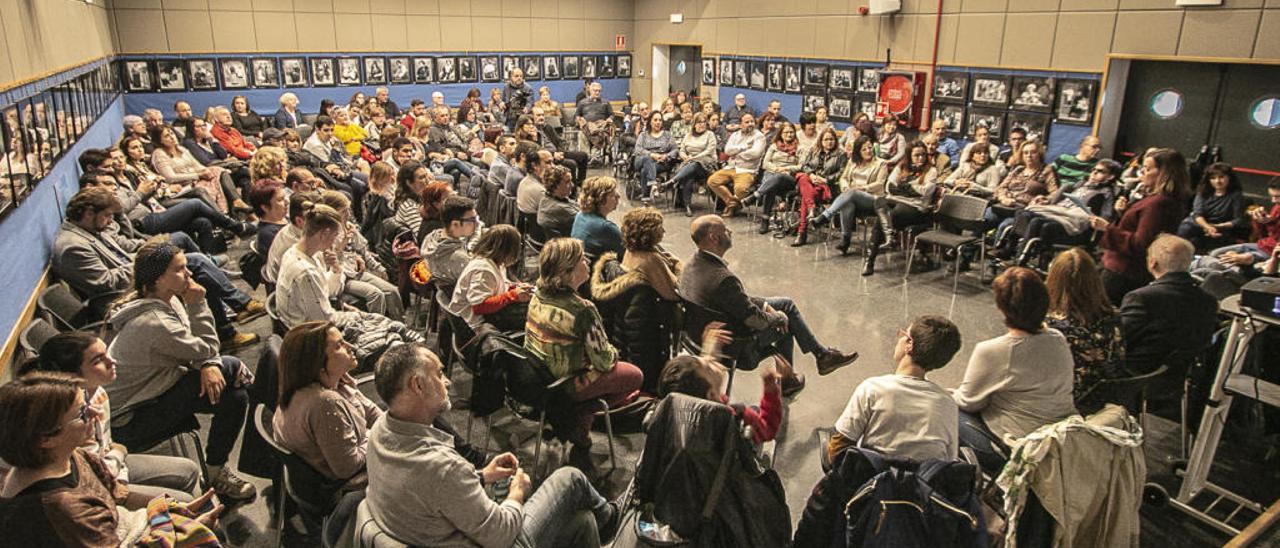 Un centenar de personas participó en la reunión entre Somriures y representantes políticos.