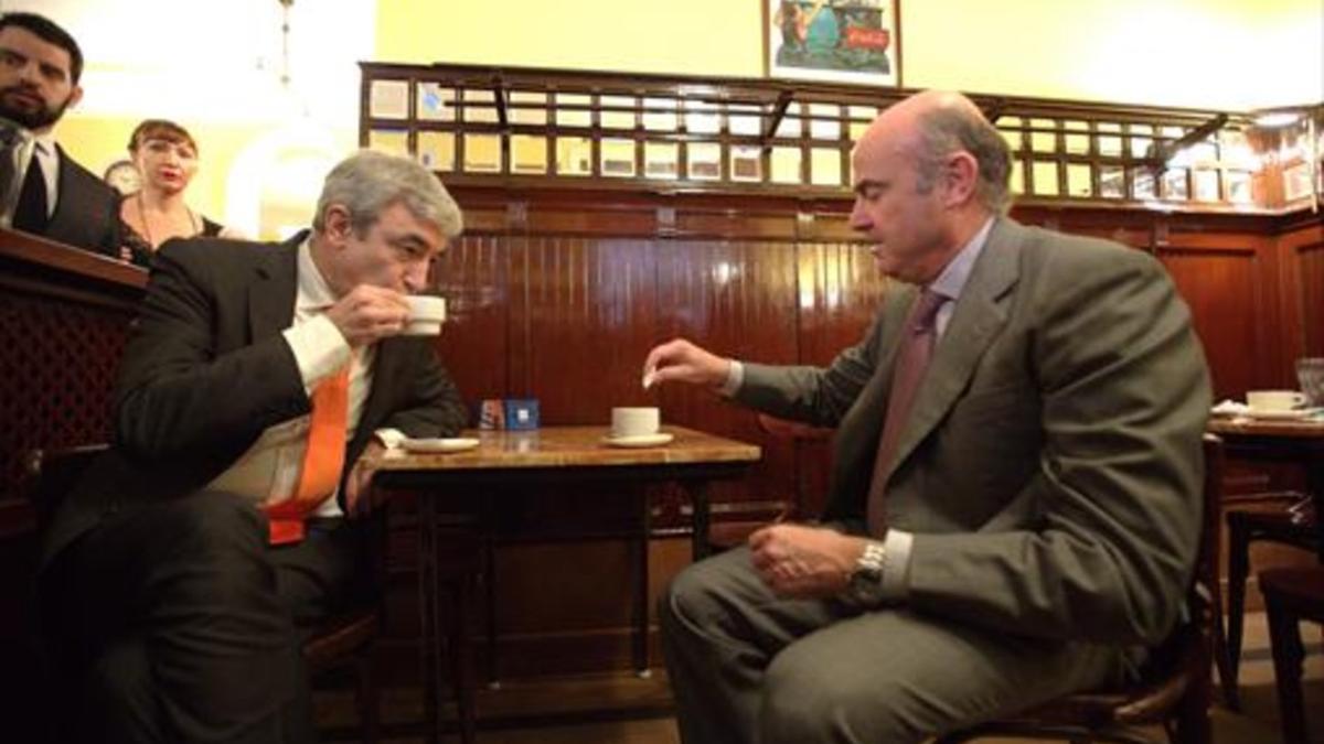 El ministro de Economía, Luis de Guindos (derecha), toma un café con el diputado de Ciudadanos Luis Garicano en un bar próximo al Congreso, ayer.