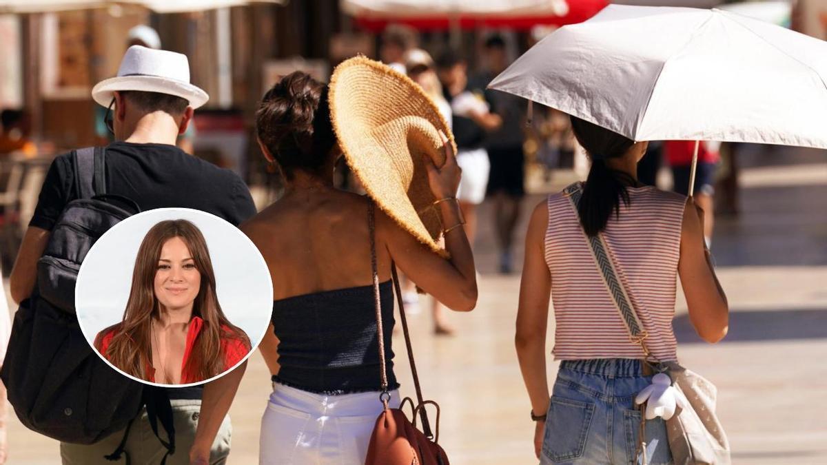 Unas personas se aíslan del sol durante un paseo por la ciudad.
