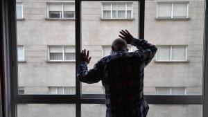 Una persona mayor que vive sola mira por la ventana en su domicilio de Pontevedra, en una imagen de archivo.