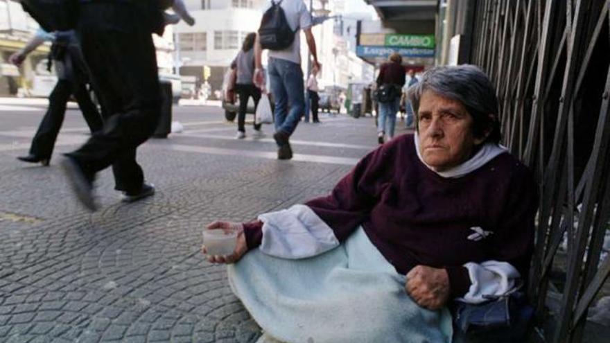 Una mujer pide lismosna en la calle. / efe