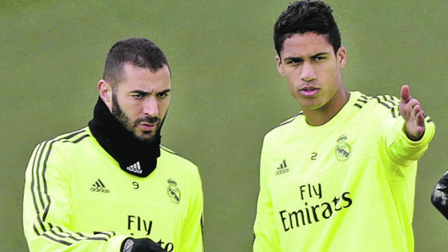 Benzema charla con Varane al inicio de un entrenamiento.