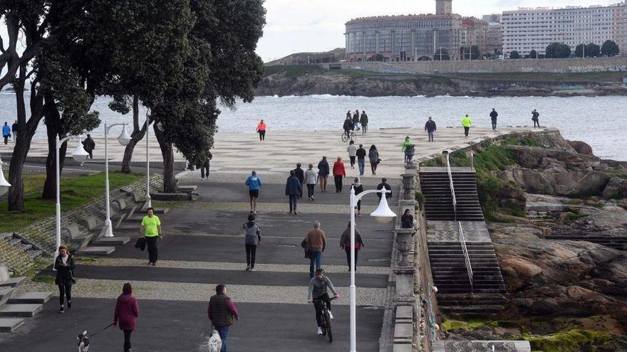 Viandantes pasean en un día nublado en la explanada junto a Las Esclavas, en A Coruña.