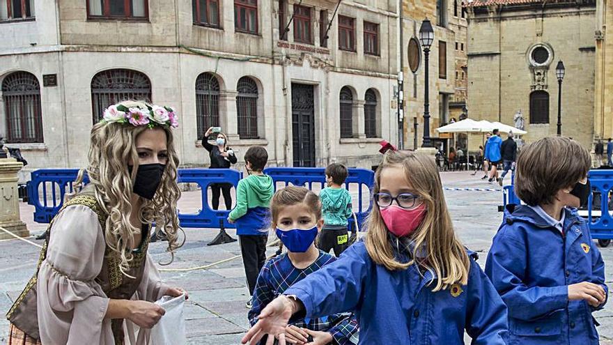 Por la izquierda, una xana, Carmen Valledor, Claudia García y Javier García, jugando a la rana, ayer, en la plaza de la Catedral. | Nazaret Quintas