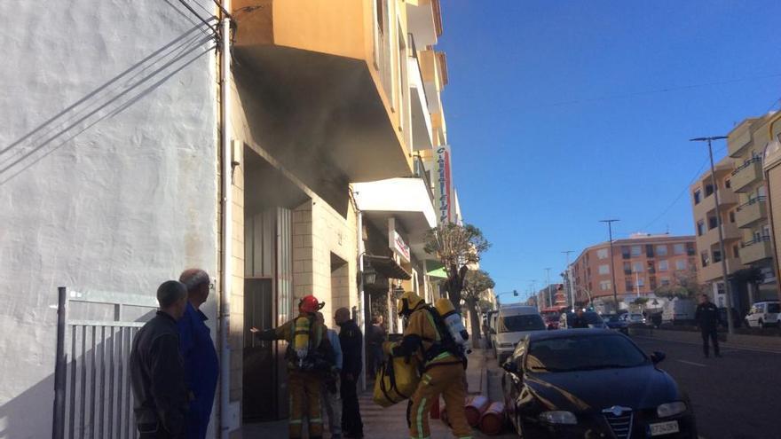 Los bomberos entran en el taller; en el suelo, las botellas de butano.