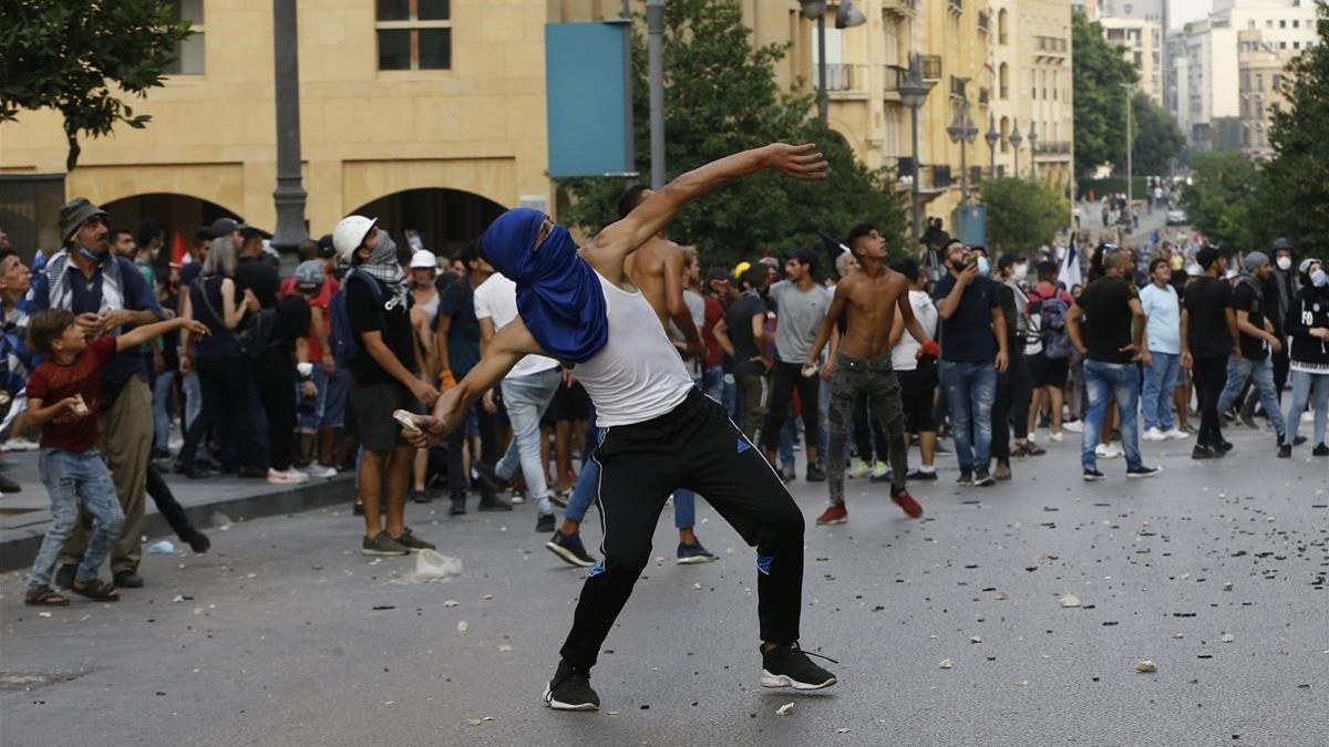 Un manifestante lanza una piedra contra la policía durante las protestas en Beirut (Líbano).