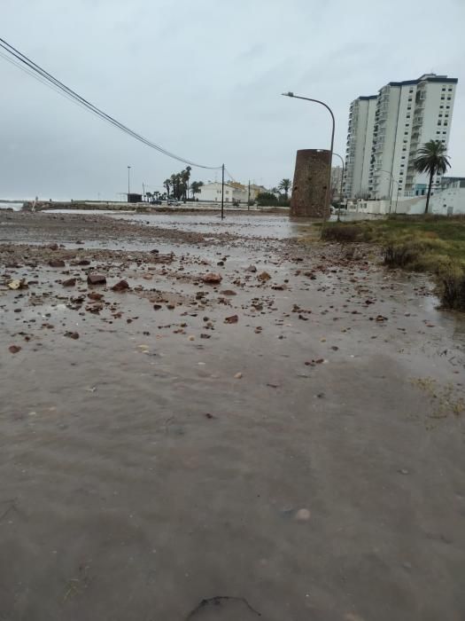 Agua y arena invaden el paseo del Puig.