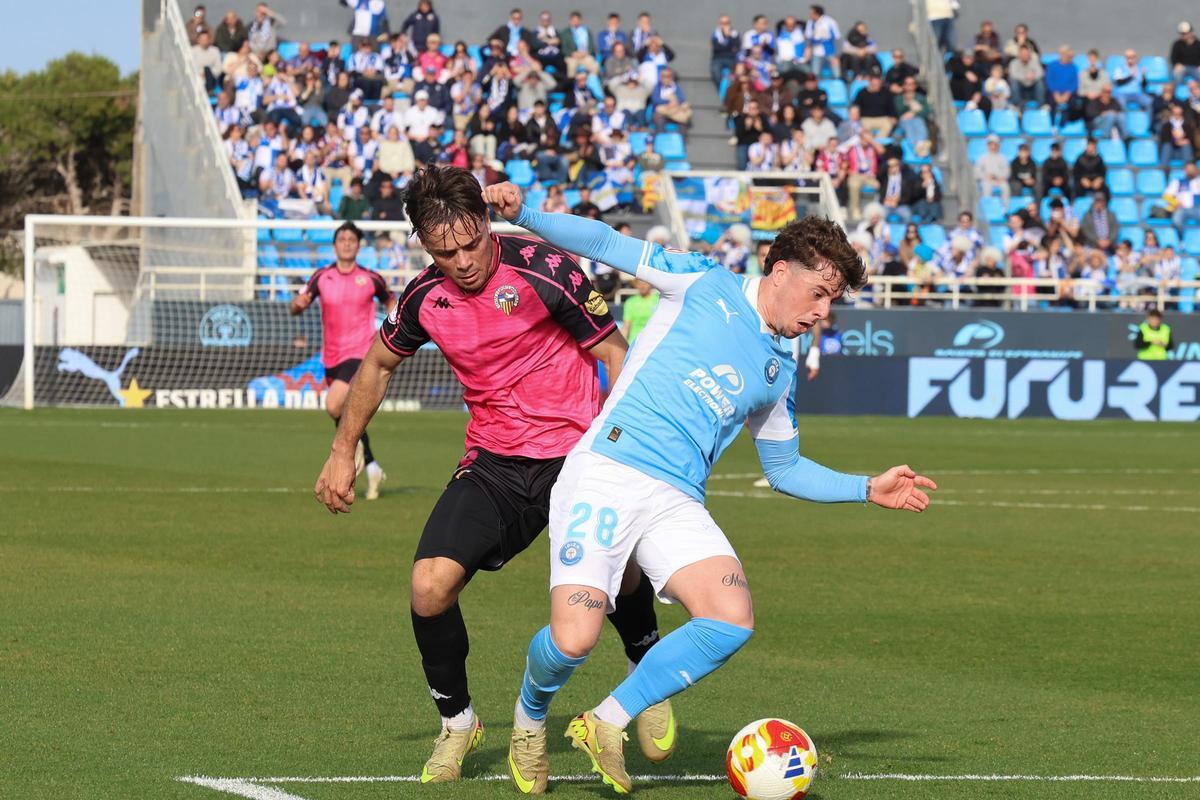 El extremo de la UD Ibiza, Izan Yurrieta, trata de zafarse de la presión de un jugador del CE Sabadell.