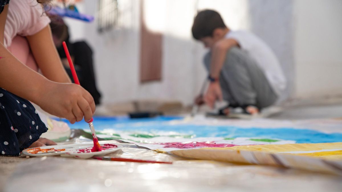 Dos menores realizan actividades artísticas en una casa de acogida.