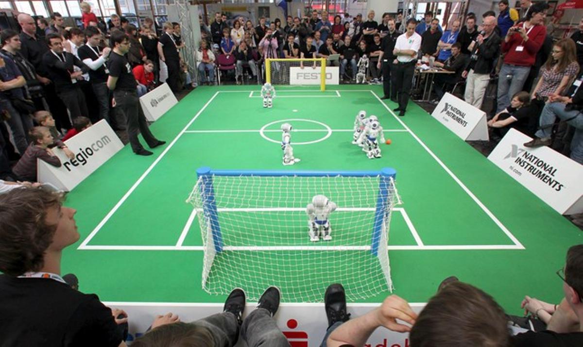 Varios espectadores observan el partido de robots disputado en el ámbito del Abierto Robo-Cup alemán 2010 en Magdeburg (Alemania). Doscientos ochenta equipos compiten en la novena edición de esta competición. El ganador se clasificará para el campeonato mundial que se disputará en Singapur del 19 al 25 de junio de 2010.