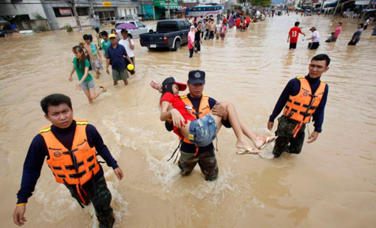 Un soldat porta una dona ferida durant una inundació al districte de Hat Yai, en una província al sud de Bangkok. Els transports i les comunicacions han quedat tallats, i els turistes tenen problemes per tornar als seus països a causa de les pitjors inundacions en dècades al sud de Tailàndia.