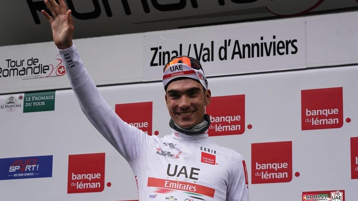 Juan Ayuso saluda desde el podio del Tour de Romandía.