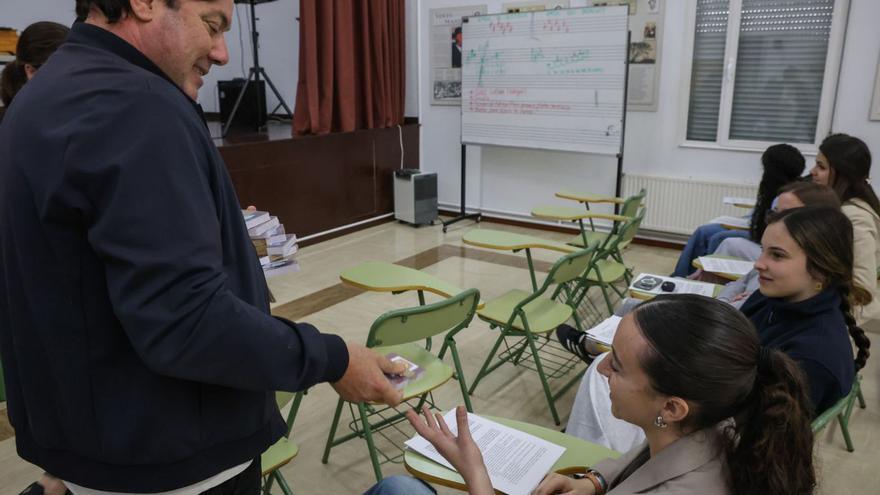 Cordal entrega a una alumna el juego de naipes que repartió ayer con la edil de Mocidade. | I. Abella