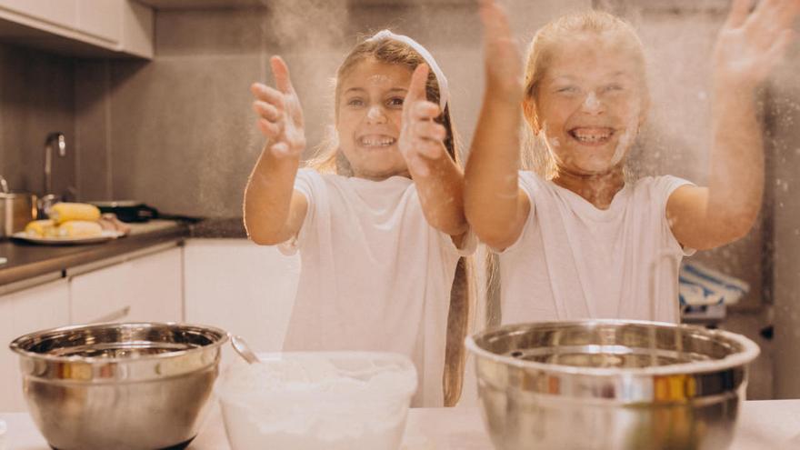 Dos infants preparant una recepta a la cuina