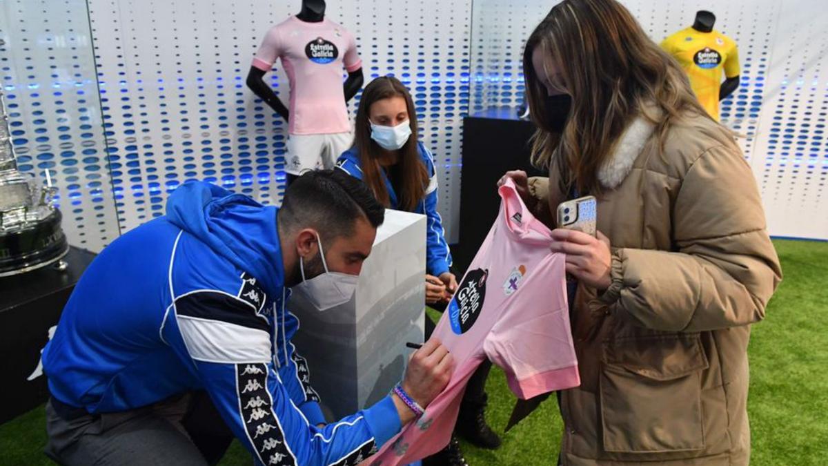 El coruñés Mackay firma la camiseta rosa a una aficionada. |  // V. ECHAVE