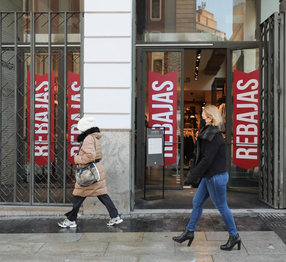 Transeúntes pasan por delante de un establecimiento durante la temporada de rebajas.