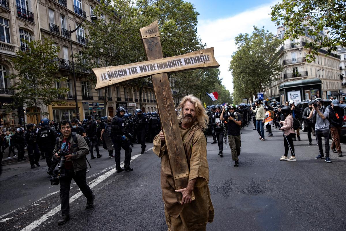 Un manifestante carga con una cruz con el mensaje La vacuna mata tu inmunidad natural , este sábado en la protesta de París. Un manifestante carga con una cruz con el mensaje La vacuna mata tu inmunidad natural , este sábado en la protesta de París.