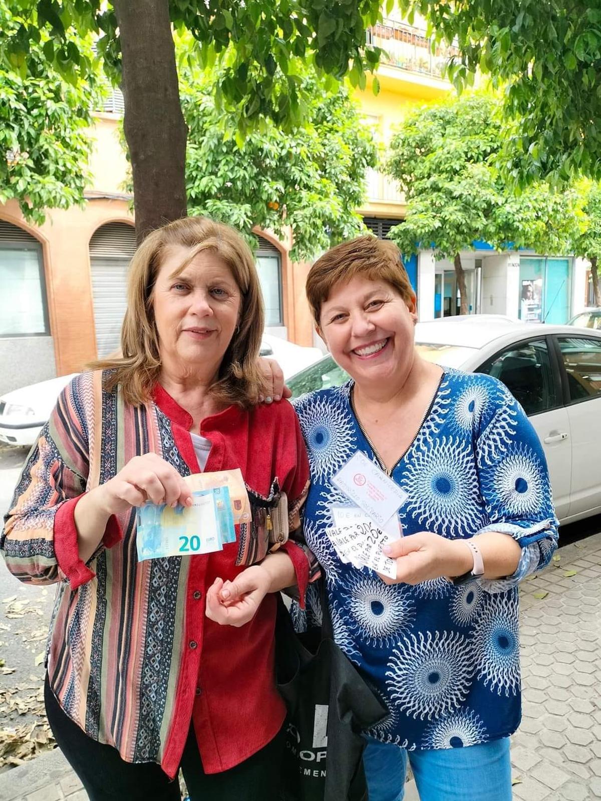 Entrega de los vales de la charcutera del mercado de abastos del Cerro del Águila a la voluntaria del rastrillo solidario.