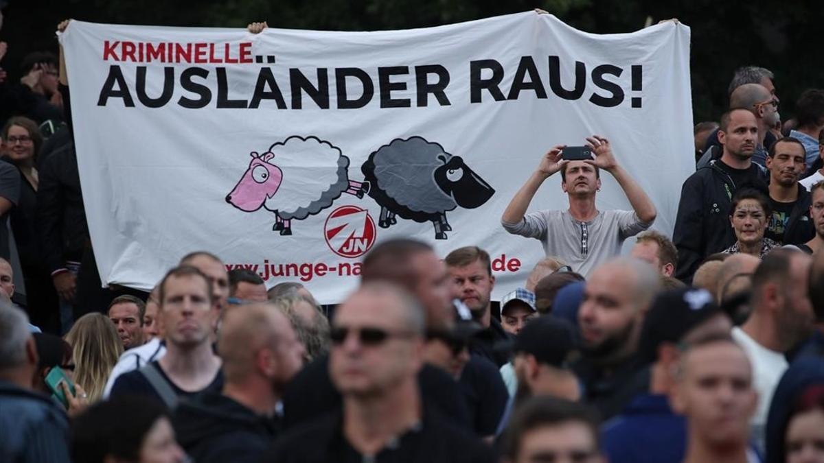 Manifestantes de extrema derecha  en Chemnitz llevan un pancarta que dice &quot;Criminales extranjeros fuera!&quot;