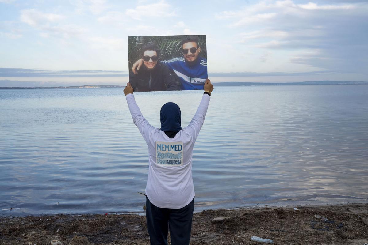-FOTODELDÍA- GRAF1391. MENZEL BOURGUIBA (TÚNEZ), 05/02/2025.- Una persona posa con los retratos de sus familares desaparecidos este miércoles, enMenzel Bourguiba (Tunez). Familias de tunecinos muertos o desaparecidos en el Mediterráneo, con flores en mano, se reunieron en la playa Rondeau de Menzel Bourguiba para rendir homenaje a las víctimas de la migración, conmemorando la tragedia de Tarajal en Ceuta (España) en 2014 y el naufragio ocurrido el año pasado, en el que murieron al menos 18 tunecinos. EFE/ Severine Sajous. -FOTODELDÍA-