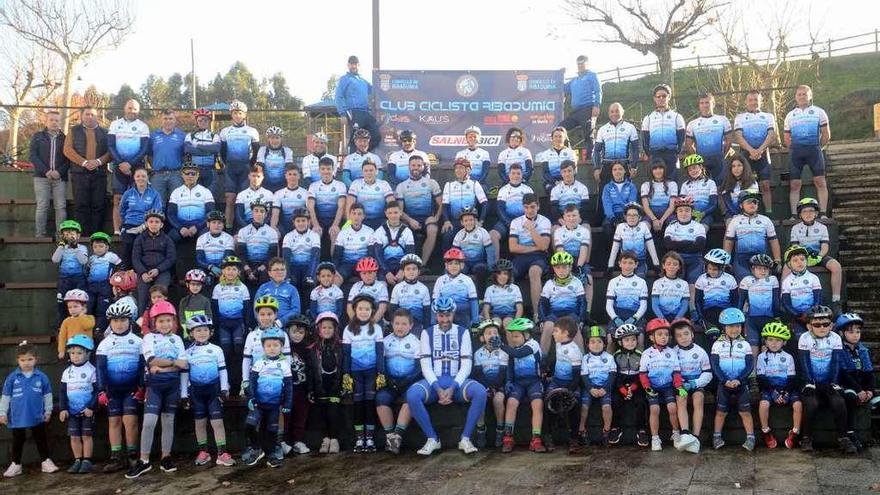 Los alumnos de la escuela del Club Ciclista Ribadumia rodean a la gran referencia de este deporte en la comarca, Gustavo César Veloso.// NP