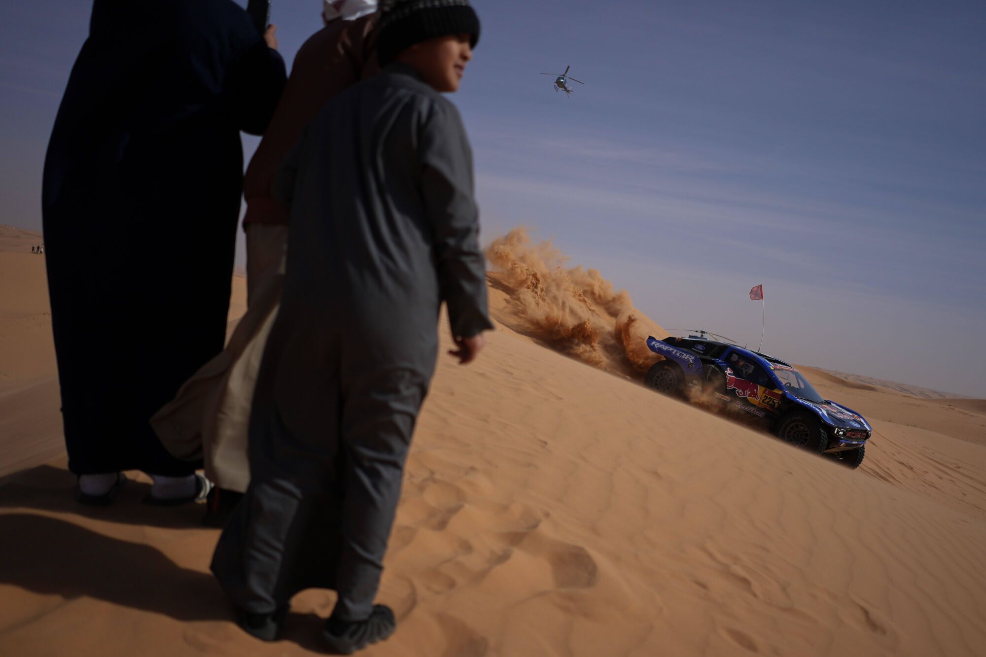 Spectators watch driver Carlos Sainz and co-driver Lucas Cruz competing during the sixth stage of the Dakar Rally between Hail and Riyadh, Saudi Arabia, Friday, Jan. 9, 2026. (AP Photo/Thibault Camus). EDITORIAL USE ONLY/ONLY ITALY AND SPAIN