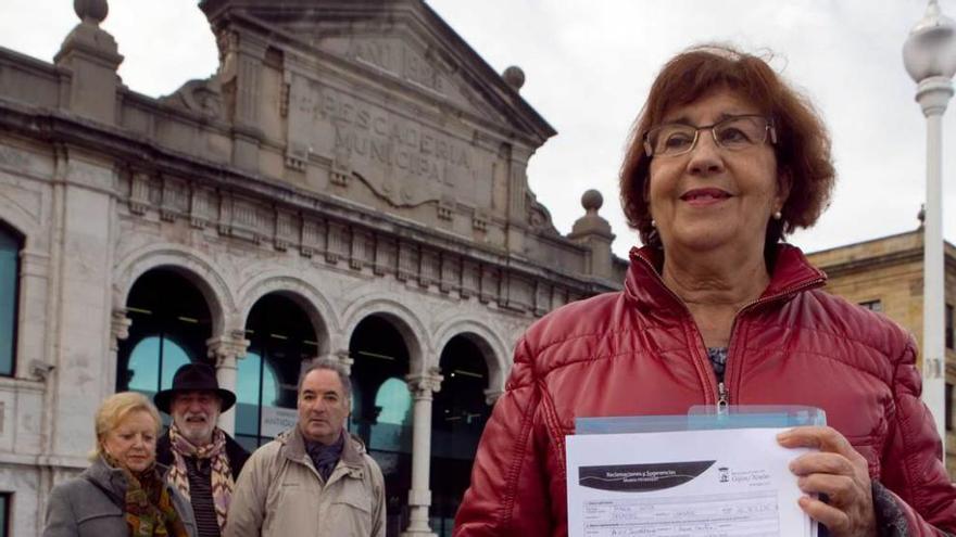 Maite Cuevas, acompañada de otros vecinos, muestra las firmas que llevaron a registrar al Ayuntamiento.